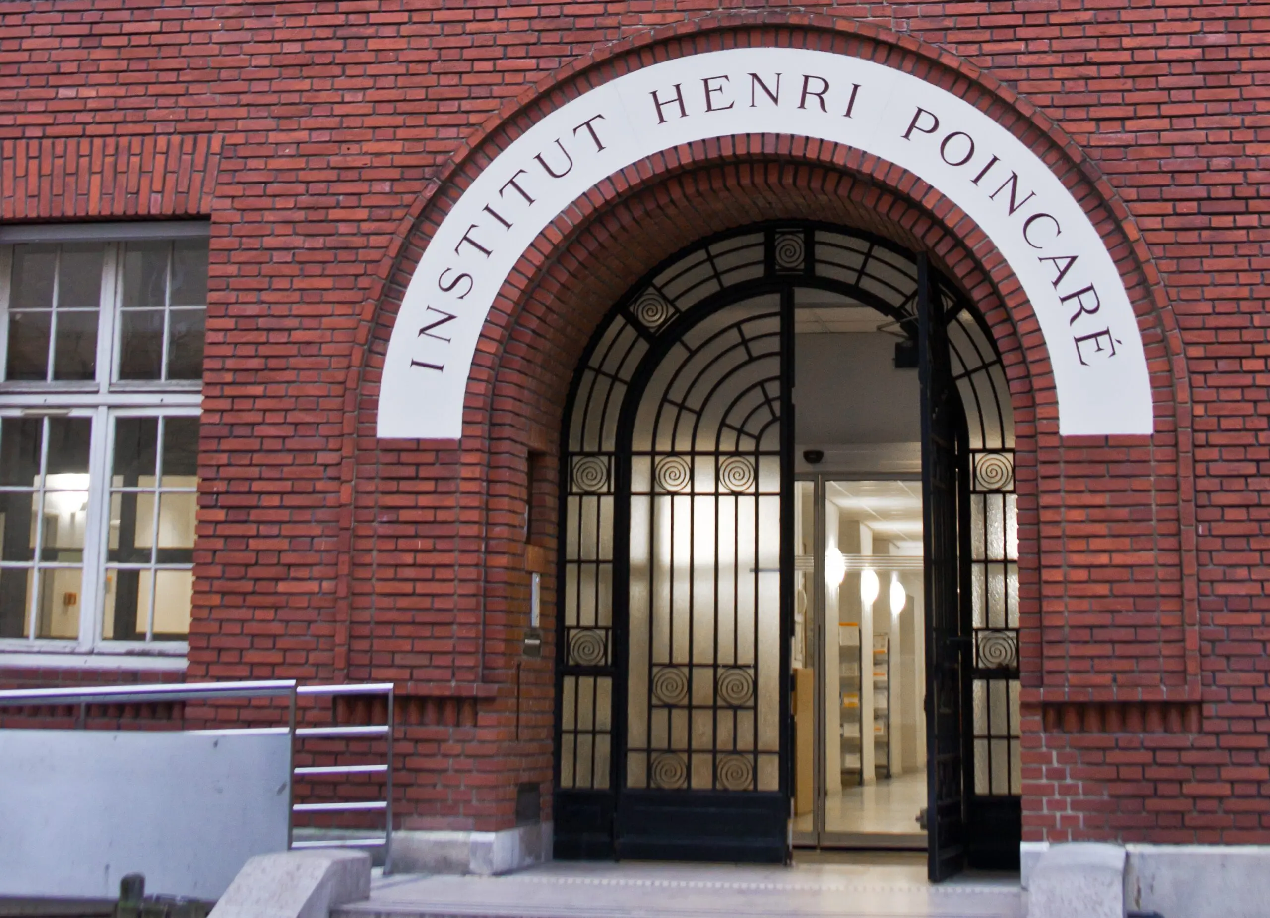 entrée de l'institut henri poincaré avec arche en brique rouge et porte ornementale