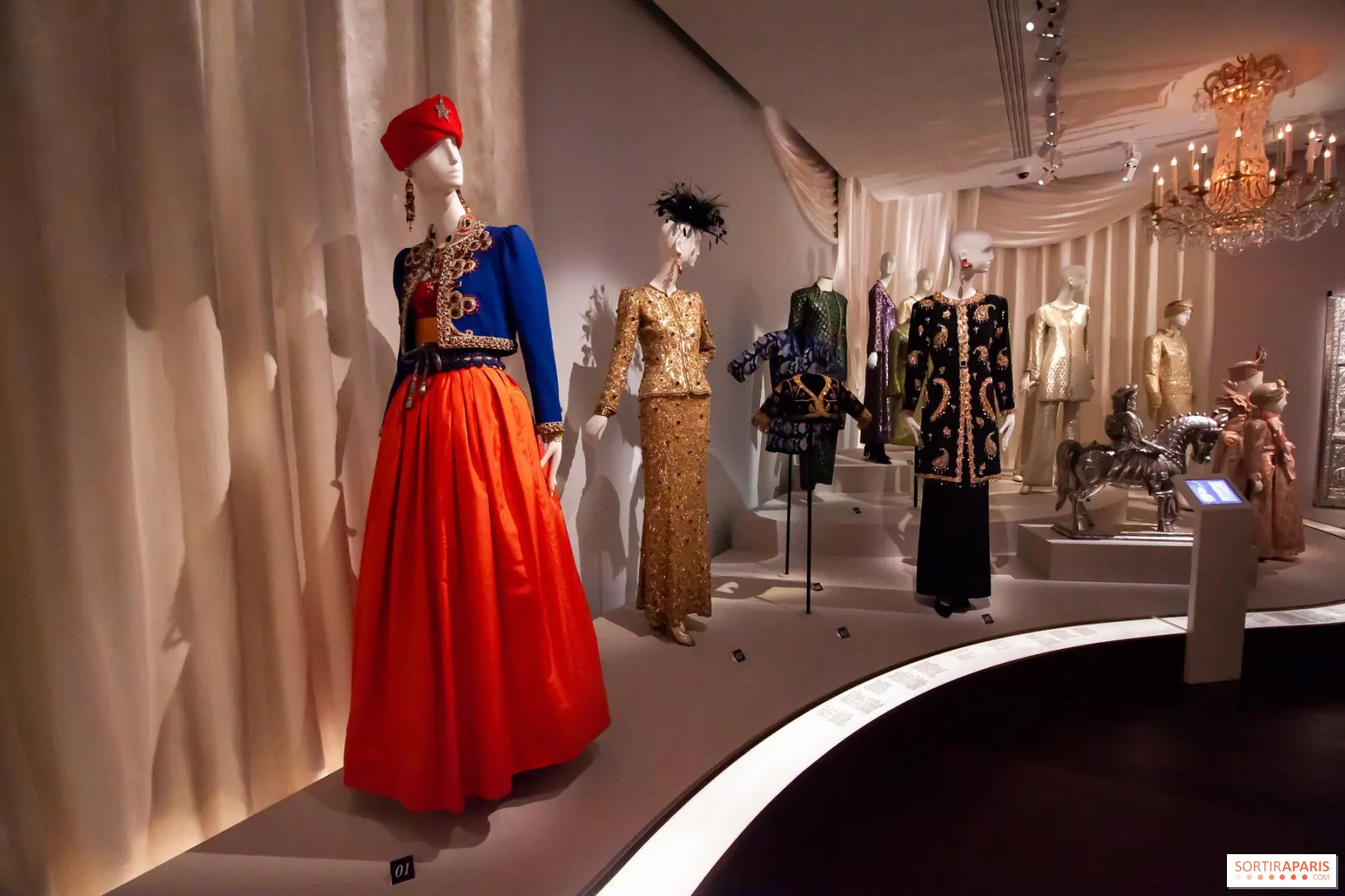 exposition de robes haute couture ysl au musée, mannequins en tenues dorées et rouges