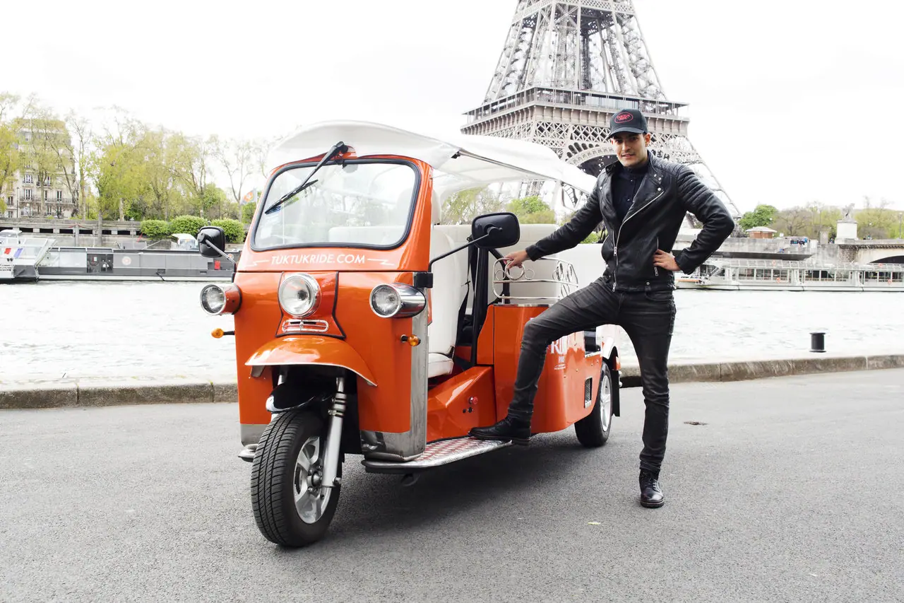 découverte insolite de paris en tuk tuk avec la tour eiffel en arrière-plan