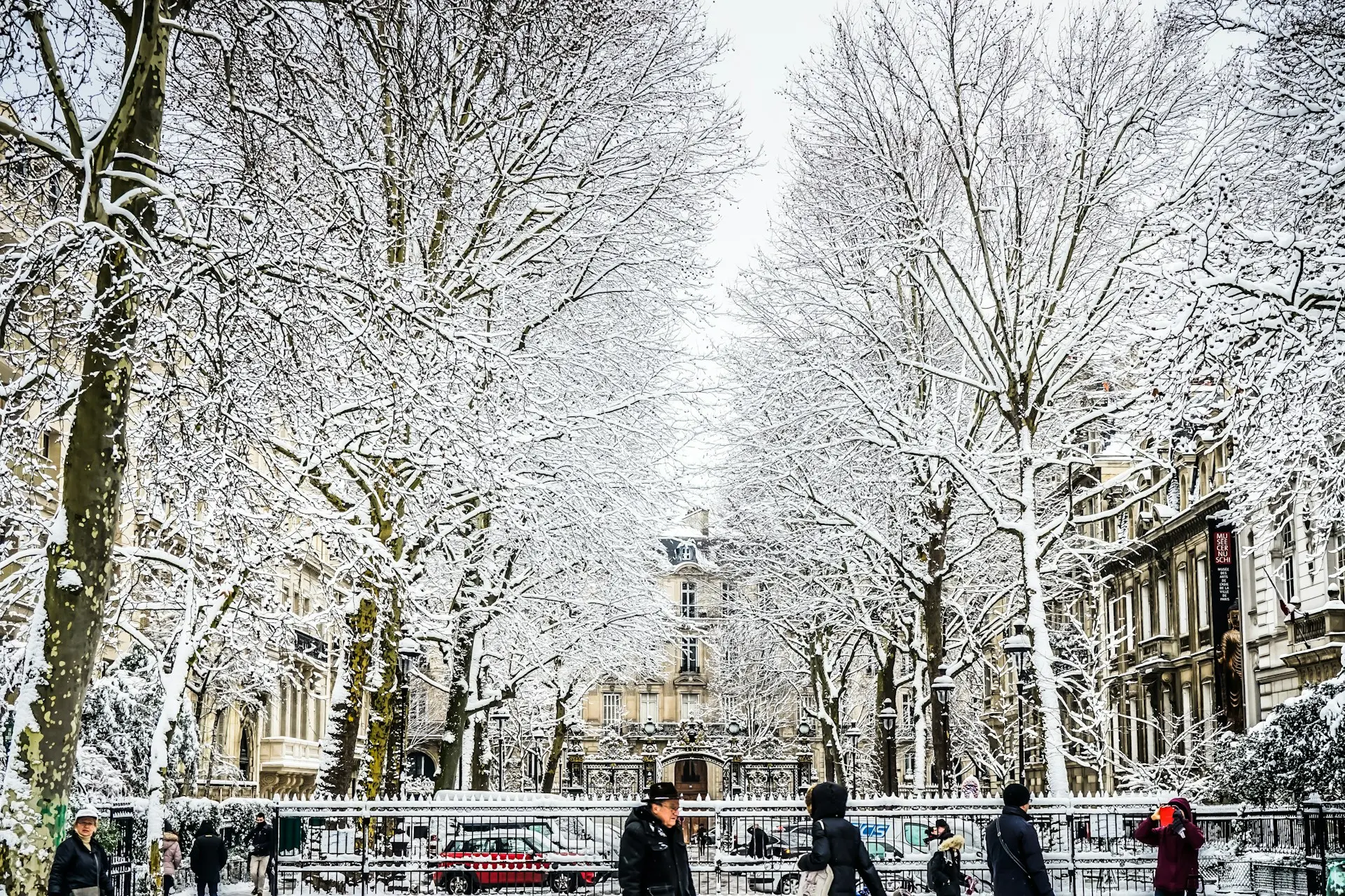 avenue des champs-élysées sous la neige avec arbres enneigés et passants en hiver à paris