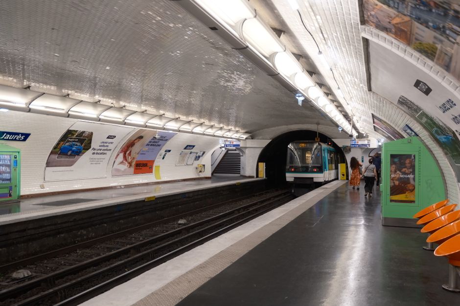A snapshot of Jaurès station in Paris with a metro train arriving on the platform.