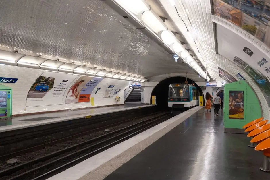 A snapshot of Jaurès station in Paris with a metro train arriving on the platform.