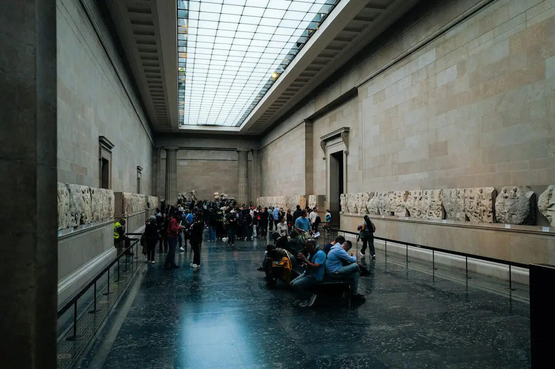 People viewing sculptures in a grand museum hall