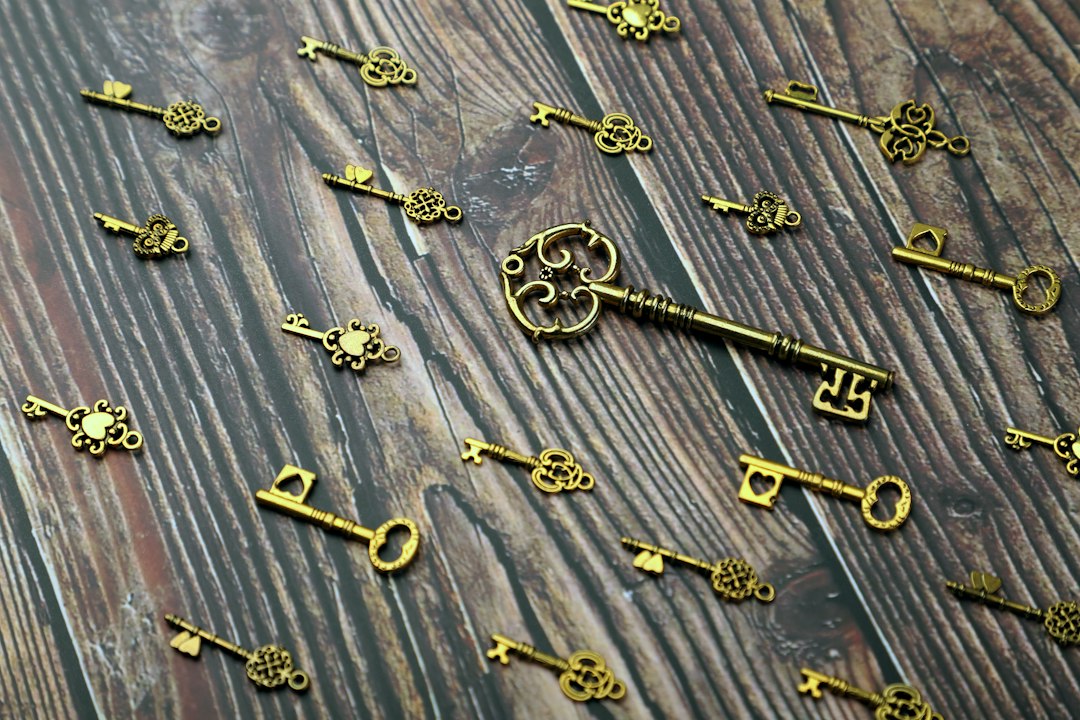silver and gold skeleton key on wooden surface