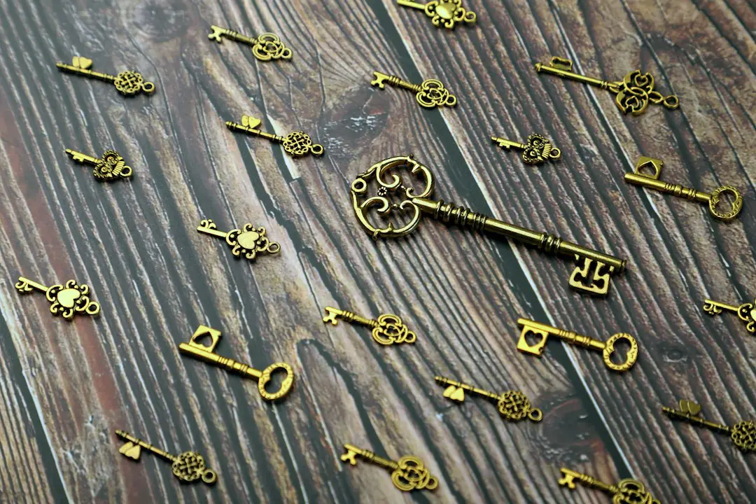 silver and gold skeleton key on wooden surface