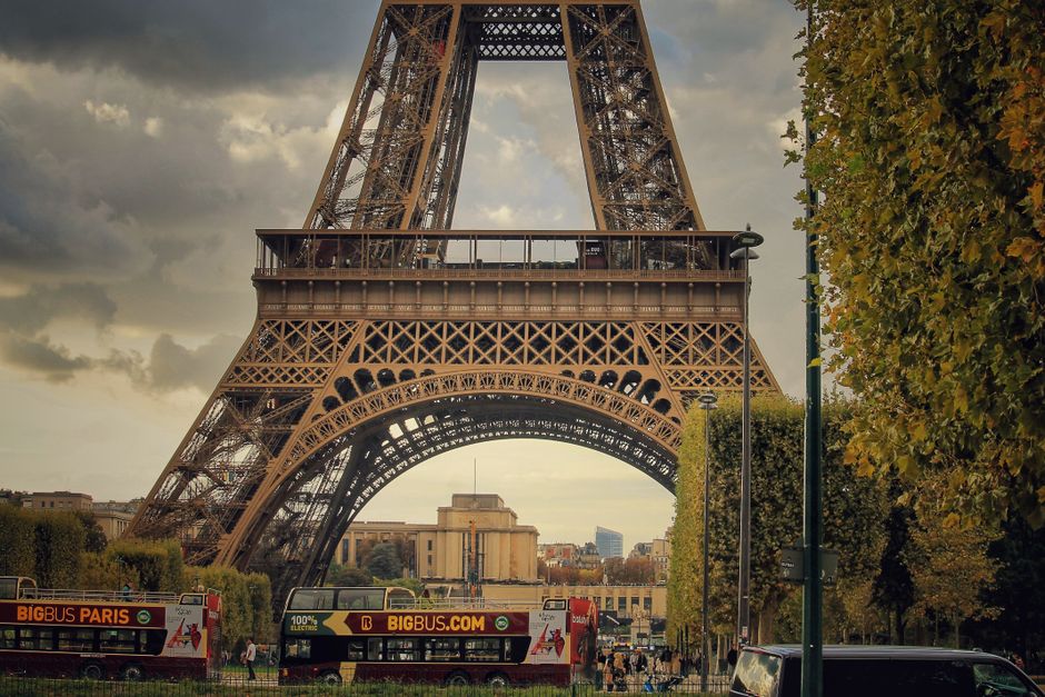 Captivating view of the Eiffel Tower amidst Parisian city life and sightseeing buses.
